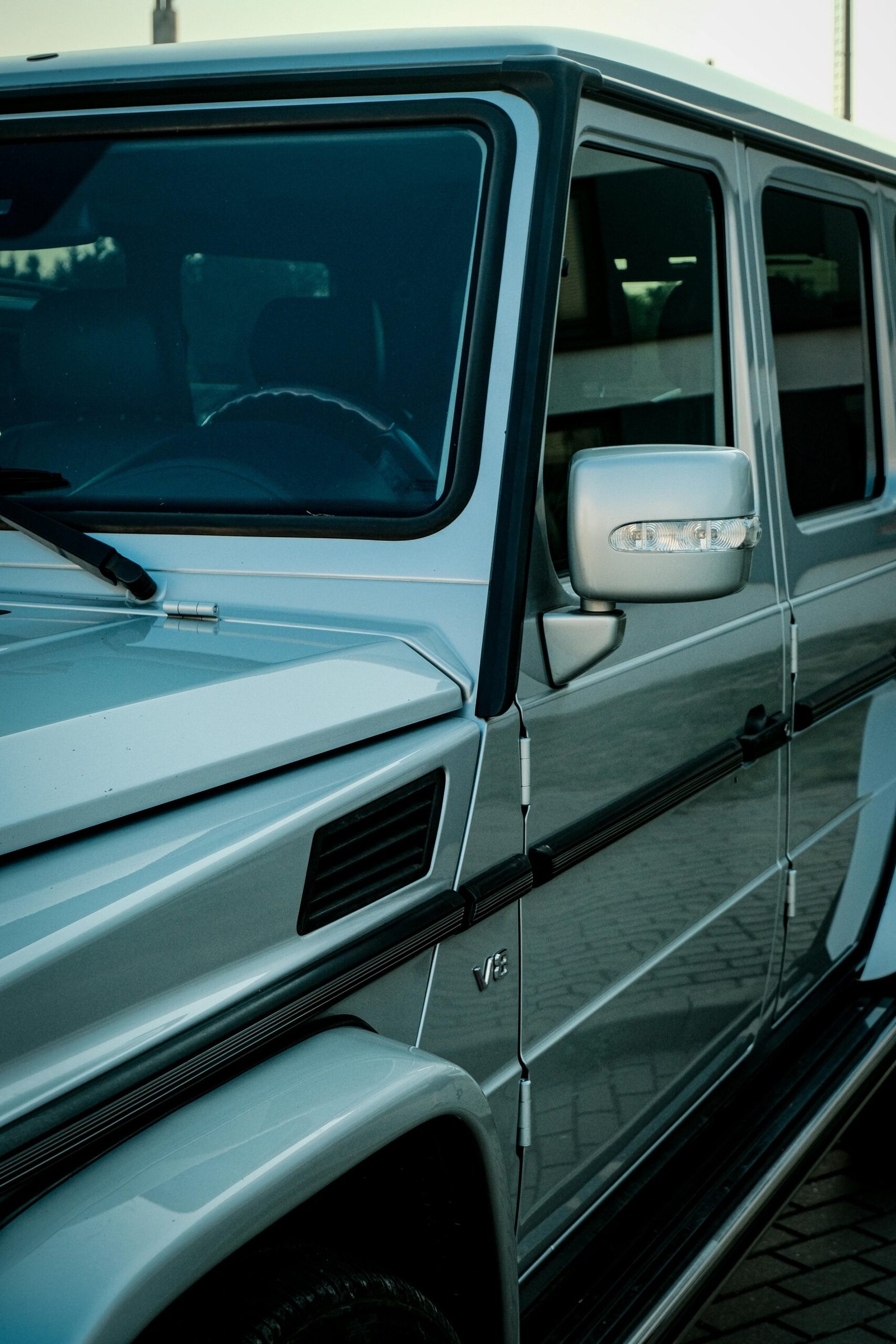A detailed side view of a luxury SUV with chrome accents parked in an urban area.